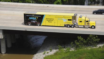 Semi truck with ServiceMaster Restore branding driving across bridge