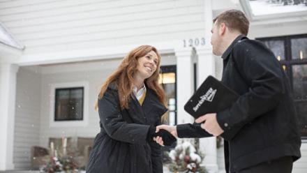 worker and woman shaking hands outside