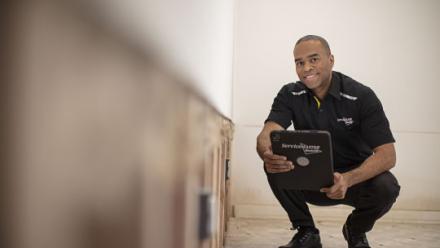 man crouching with tablet
