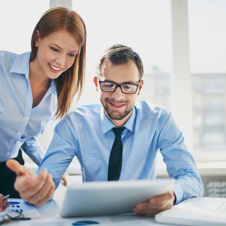 Two professionally dressed people looking at a work report