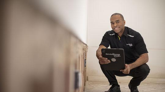 man crouching with tablet
