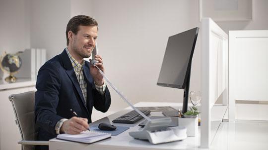 employee on the phone in front of a computer
