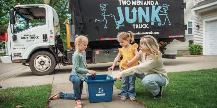 Family recycling in front of Junk Truck