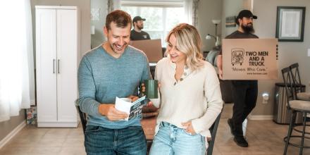 A couple smiles as they look at a junk removal business pamphlet