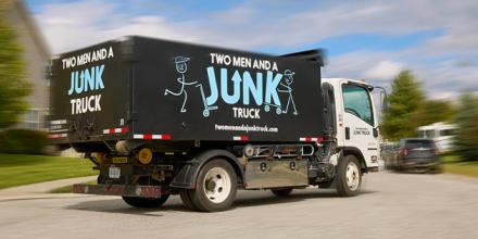 A TWO MEN AND A JUNK TRUCK branded truck drives by