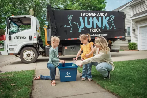 Family recycling in front of Junk Truck