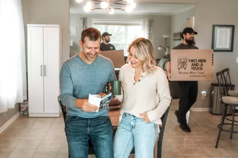 A couple smiles as they look at a junk removal business pamphlet