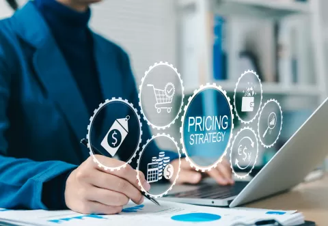 Pricing strategy icons shows from computer screen as someone writes
