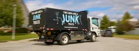 A TWO MEN AND A JUNK TRUCK branded truck drives by