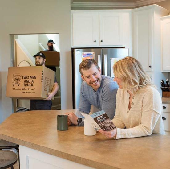Man and woman at counter with movers in background